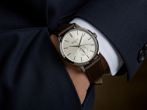 Minimalist leather-strap wristwatch paired with a formal suit